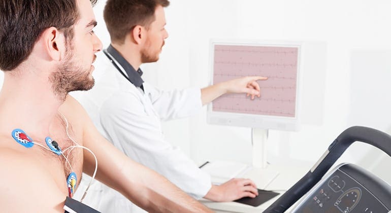 Cardiologist Technologist explaining Stress Testing results for patient on a treadmill.