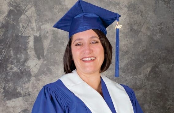 Marilyn in grad gown, joyful with the new career as an Education Assistant.