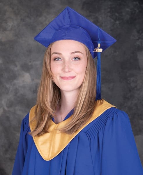 Maddie hold her head high wearing a gown at her Graduation Ceremony as an Educator Assistant.