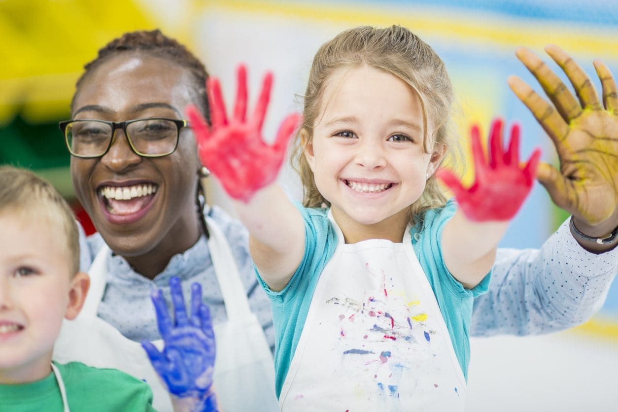 Early Childhood Educator with kids with painted hands