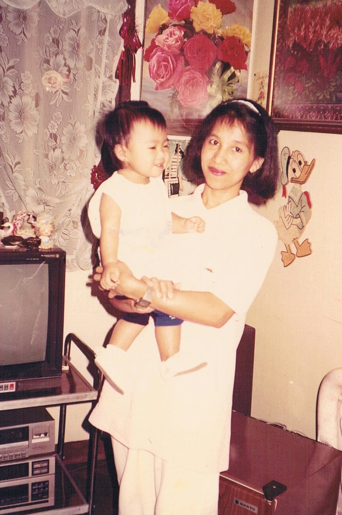 Faith's mother carrying her in her arms at their home country, the Philippines.